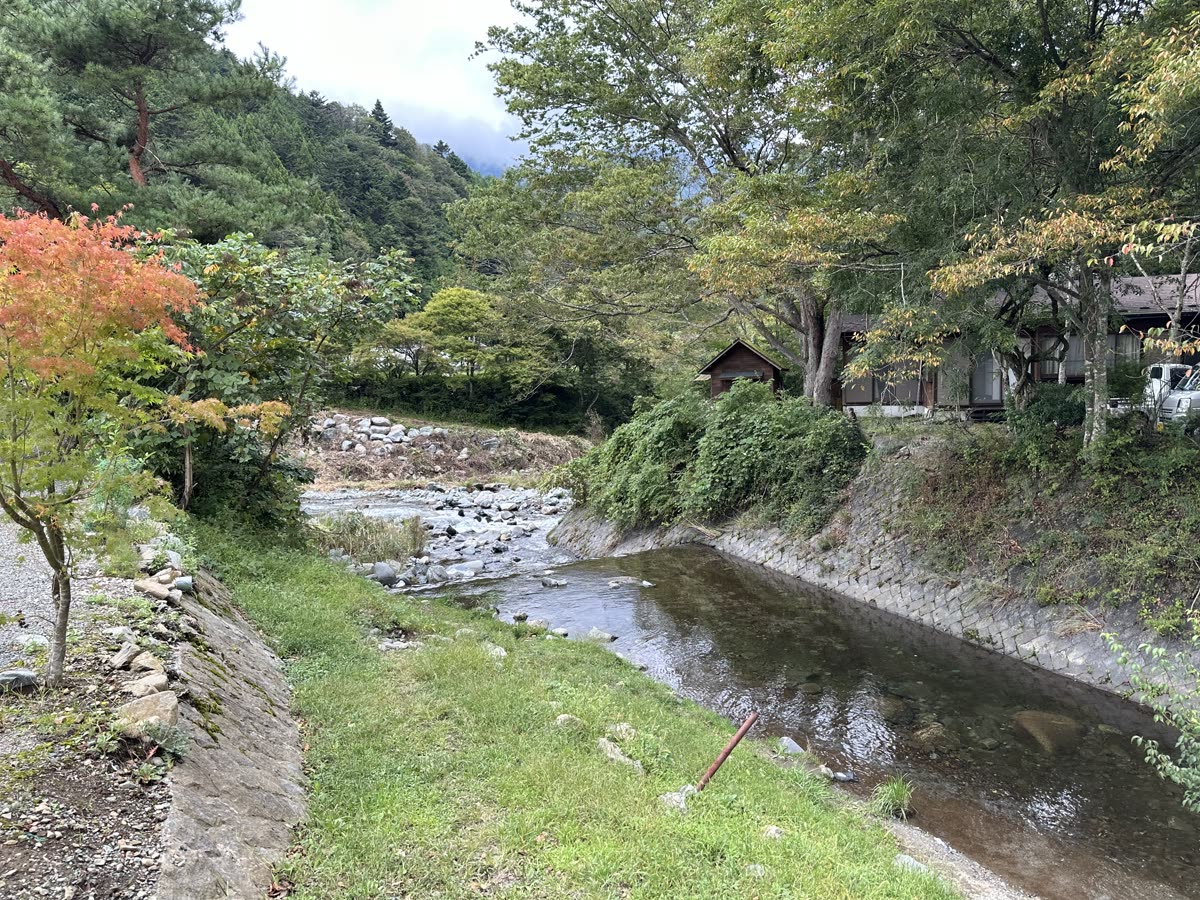 キャンプ場のそばを流れる川と色づき始めた木々